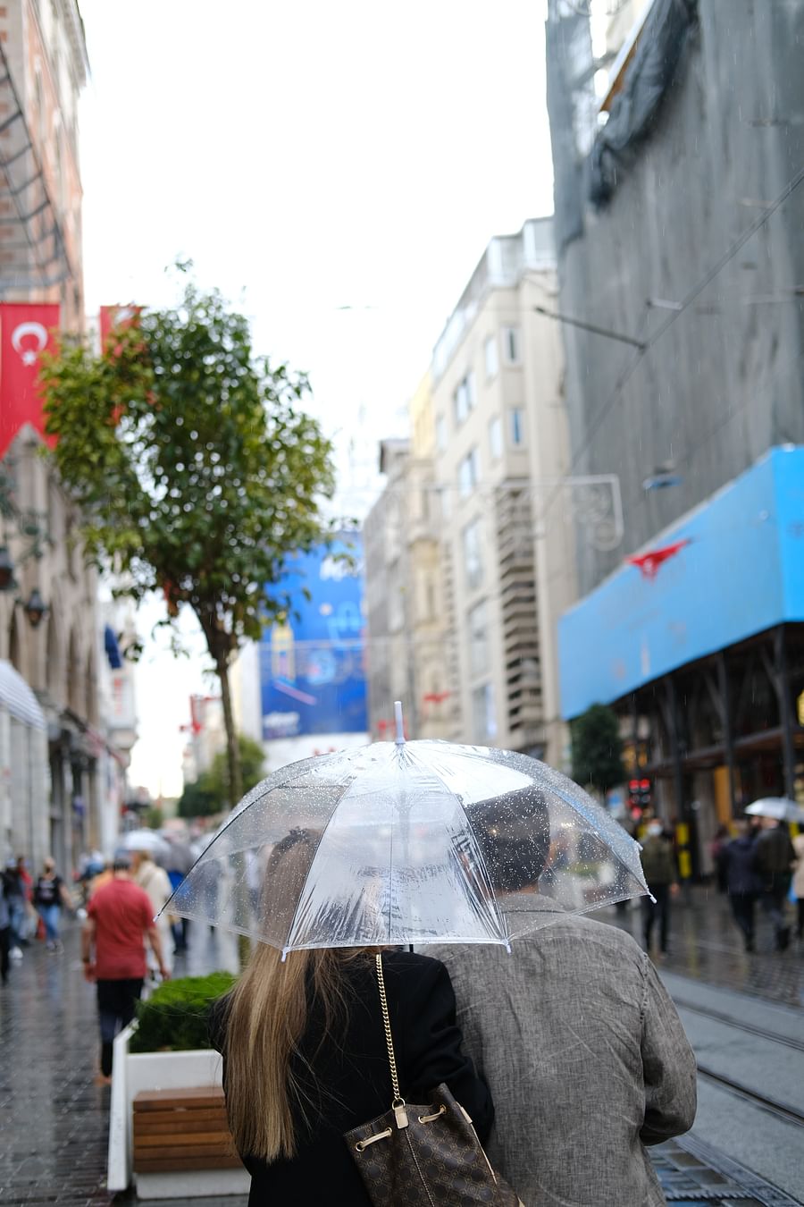 Fashionable woman wearing an orange parka on a city street